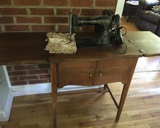Singer sewing machine in cabinet.