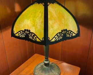 Antique slag glass table lamp. There is one broken panel as photographed