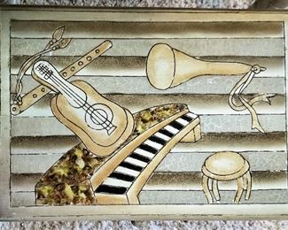 View of the top of the nesting tables. Musical instruments are depicted on the top of each table. 