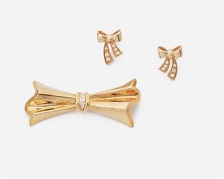 2011
Two Gold And Diamond Bow Jewelry Items
14-18k yellow gold
Comprising a bow brooch set with three single-cut round diamonds (2" W x .875" H) and a pair of bow earrings set with twelve full-cut round diamonds (.5" W x .625" H), the diamonds in the lot totaling approximately 0.25ct and graded G-H color, VS-SI clarity
18k gold brooch: 7.5 grams; 14k gold earrings: 4 grams
3 pieces
Estimate: $400 - $600