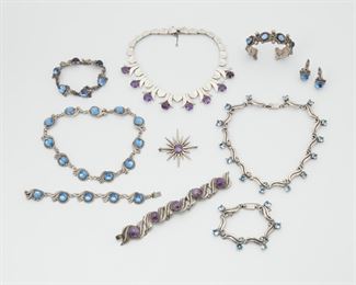 2183
A Large Group Of Stone Set Mexican Jewelry
Second quarter 20th century
Comprising a Miguel Melendez amethyst and silver star shaped brooch, marked: Taxco / Sterling / Eagle 3; a necklace and bracelet set of Emma Melendez stone set jewelry in aquamarine color, marked: Sterling / Taxco / Emma /Eagle 3; an amethyst set Talleres de Los Ballesteros necklace, Partial makers mark, further stamped: Sterling / 925 / Hecho en Mexico; an amethyst and silver link bracelet, marked: Mexico / Silver/ 122; a bracelet and earring set with blue glass, marked: Emma; a Rancho Alegre cuff bracelet set with blue glass; a Lopez necklace and bracelet set with blue glass, 11 pieces
Amethyst necklace: 15" L x 1" H; Star brooch: 2.25" L x 2.25" W
428 grams gross
Estimate: $400 - $600