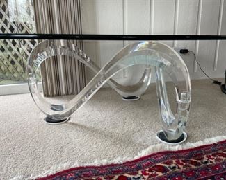 Wave pedestal cocktail table by Interlude. Lucite base with glass top. Measures 50"L x 36"W x 16"H. Photo 2 of 2 