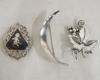 1289	LOT OF THREE STERLING SILVER BROOCH PINS. LOT INCLUDES A LEAF PIN MARKED TAXCO, A CRESCENT MARKED DENMARK & ONE MARKED SIAM. COMBINED WEIGHT IS .945 TROY OUNCES.

