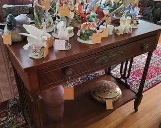 15.) Collection of porcelain birds and figurines on a mahogany sofa table with solid stretcher.   