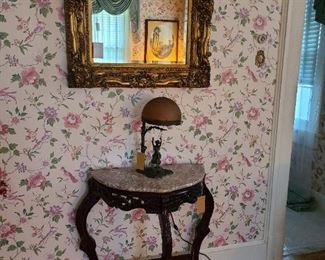 44.) Indonesian demi lune with marble top. 28"w x 16"d x 31"h.  Decorative beveled mirror set in heavy frame.