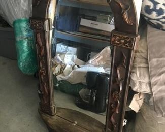 Wooden hanging wall mirror with decorative carvings and small demi-lune shelf 41x22x3   $125