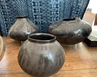 Native American black on black feather design  pot with two Mata Ortiz pots in the back ground