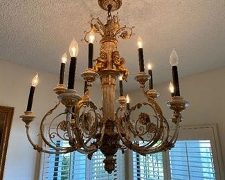Spectacular Italian carved and gilt wood and iron chandelier with 12 lights and cherubs. Ceiling mount. Approx 34" top to bottom and 30" wide. SOLD No calls email only please. 