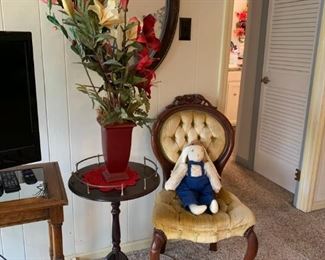 Victorian chair, Oval wall mirror, small side table, and floral arrangement 