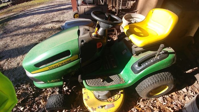 John  Deere  riding mower with tow cart sold as is.