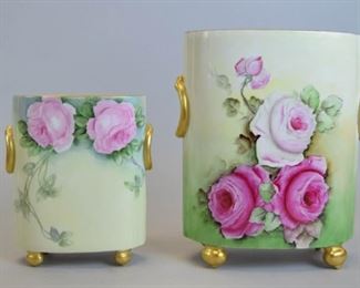 14 William Guerin Limoges Porcelain Cachepots Lot includes two artist signed William Guerin Limoges hand painted floral porcelain cache pots/vases. Raised on four gold gilt feet with two molded ring-form handles. Largest measures 9 1/2"T x 9"W with artist initialed rose motif painting. Small measures 6 3/4" T x 6 1/4" W with rose motif and artist signed M.E. Clare.