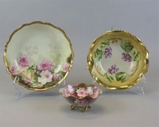 60 3 Elite Limoges Porcelain Bowls 3 hand painted Limoges porcelain bowls. All signed Elite. Serving bowl with floral decoration and gilt painted rim, 10"-diameter; 2 handled bowl with flowers and gilt painted rim and handles, 4 1/2"H x 8 1/2"-diameter; small footed bowl with floral decoration and gilt painted rim and feet, artist signed J Ros, 2 3/4"H x 5 1/2"-diameter