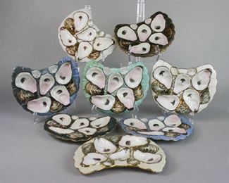 139 Set of 8 Crescent Shaped Oyster Plates Set of 8 hand painted porcelain crescent or half-moon shaped oyster plates. All unsigned, with impressed numbers 1677 on the underside. 3 with rim chips. 8 1/2" x 7 1/2"