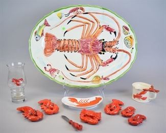 143 Grouping of Lobster & Crab Items Crescent shaped dish with hand painted lobster decoration, 7"L; Libbey glass with applied lobster decoration, 6 3/4"H; butter / cheese spreader with lobster handle, 5 1/4"L; set of 3 lobster salt & pepper shakers, each 4 1/2"L (2 missing corks); pair of lobster salt & peppers, each 3"L; crab salt shaker, 3"L x 2 1/2"H; 2 part butter melter with lobster handle, 5"L x 2 1/2"H; Italian pottery lobster platter, 20"L. Line in platter
