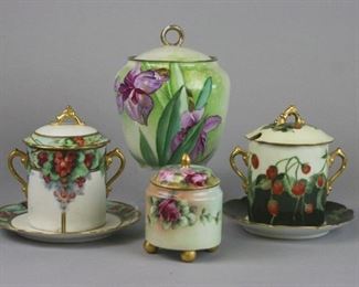 158 Grouping of Lidded Porcelain Jars Lot includes Artist signed hand painted gilt and floral biscuit jar with Ernst Wahliss Turn Vienna mark and La Princesa mark, 5 1/2"T x 6"W; jar handle and lid rim have some wearing of paint; gilt and handpainted Limoges marked jam jar and matching plate with strawberry motif, 5 1/2"T; artist initialed hand painted gilt and grape motif jam jar with Vienna Austria mark and matching plate, 5 1/2"T, no chips; small footed jam jar with rose motif, no markings, 4"T, some paint wear on rim.