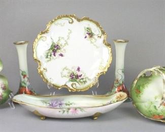 163 Porcelain Candlesticks and Serving Dish Grouping Lot includes two gilt and hand painted porcelain candlesticks marked T & V Limoges France, 9"T x 5"W, some wear on paint, no chips; small gilt and rose motif hand painted candy dish with LS&S Limoges marking, 8 1/2"L x 8"W, no chips; Artist signed hand painted gilt and floral motif La Seynie Limoges freeform porcelain bowl, with scroll foot detail, marked La Seynie Limoges France, 14 1/2"L x 6 3/4"W, no chips; Old Abbey Limoges gilt and floral motif plate, 12"diameter, repaired; Tirschenreuth hand painted gilt and floral handled dish, marked PT Bavaria Porcelain, 11"L x 10"W, some wear on handle paint, no chips