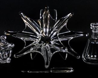 181 Baccarat Crystal Grouping 4 Baccarat crystal items. Stella star form center bowl, 15"-diameter; fountain pen, 7 3/4"L; small decanter, 7"H; lidded condiment jar with spoon, 4 3/4"H. Bowl, condiment jar & spoon and decanter all with etched Baccarat France marks, pen signed Baccarat. Chip on tip of pen.
