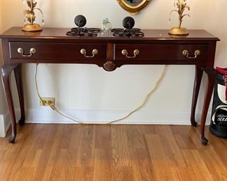 Mahogany console table with cabriole legs, brass detailing and shell accent.