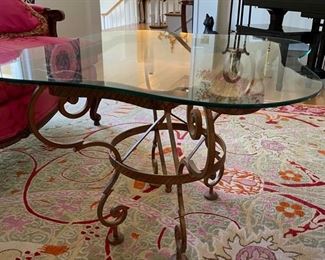 Glass coffee table with metal scroll leg pedestal base. Measures 24"W x 21"D