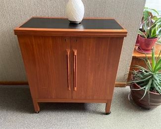 Solid teak mid century rolling bar. Interior includes wine rack and two drawers. Top  folds open to create a larger bar top.