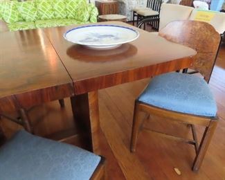 Mid Century Burled Wood dining table with 4 matching chairs. The table to rests on a base of curved burled wood columns.
