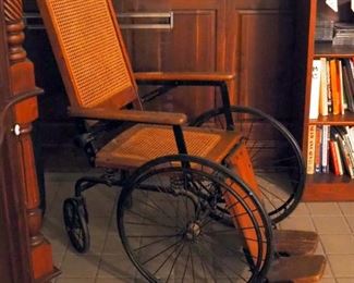 Antique Arrow 4-Wheeled Iron And Wood Wheelchair With Cane Seat And Back