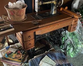 Antique Singer treadle sewing machine.  Plenty of sewing notions to match.