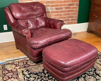 RED LEATHER ARMCHAIR & OTTOMAN | By Leathercraft Inc., Conover, NC; including an armchair (h. 35 x w. 34 x 45 in.) and a matching ottoman (h. 14 x w. 30 x d. 22 in.) [worn leather] 