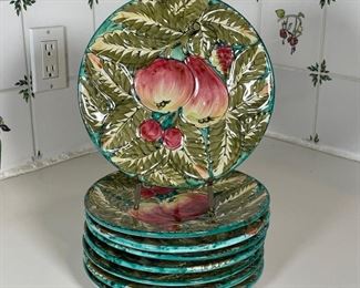 (8pc) ITALIAN POTTERY PLATES | Textured and hand painted with fruits, marked on the bottom "ITALY / 1027… FRUTTABELLA" [one with crack/rough repair, some with chips]; dia. 9 in. 