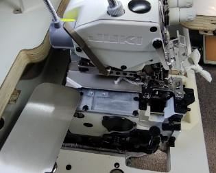 The Juki MO-6814S is Juki’s most popular four-thread serger. It can be used not only as a four-thread serger but also a wide three-thread or narrow three-thread serger. This machine is the most popular serger out there. The 6814S is widely applicable to the sewing of light-to-medium weight materials. Since the machine is provided with a needle thread take-up mechanism and a looper thread take-up lever, high-quality, well-tensed soft seams are made with a beautiful texture which flexibly correspond to the elasticity of the materials even when run at speeds as high as 7,000 stitches per minute. In addition, the machine has a wider and brighter needle entry and provides improved responsiveness to the materials, thereby helping you use the machine more easily. The optimally-balanced design of the machine reduces both operating noise and vibration, contributing to more comfortable sewing work. Includes commercial table, pedal and upgraded Servo Motor. Sells new at Missouri Sewing Machine C