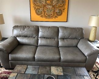 Leather sleeper sofa-like new! Part of a three-piece matching set . Color is grayish tan. $600