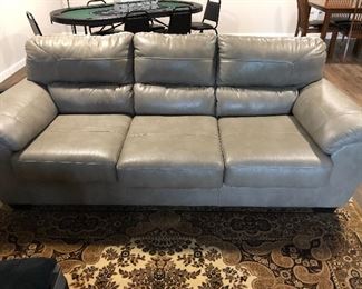 Leather sofa. Part of three-piece set. Grayish tan. $700. Like new!