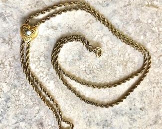 $35 Gold tone chain with sliding heart.  23"L 
