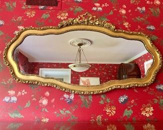 $250 - Gilded, serpentine mirror.  27.75" H x 51.5" W. 