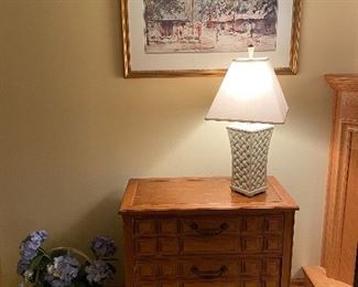Cabinet with drawers, table lamp, framed art