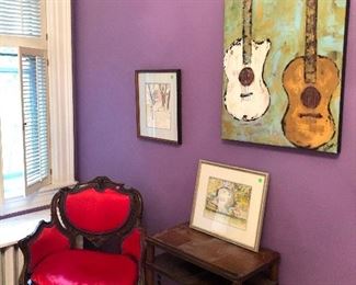 Antique armchair, side table, and framed artwork