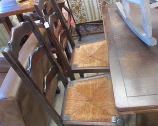 Antique ladder back chairs pair with straw woven seats.