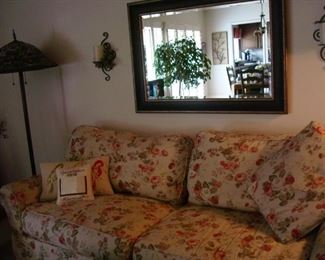 floral couch and wall mirror