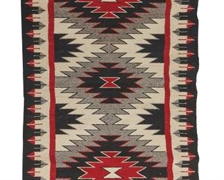 103
A Navajo Regional Rug
Mid-20th Century <br />
Woven of red, cream, grey, and black with serrated diamonds and feathered border
69.5" L x 37.5" W
Estimate: $400 - $600