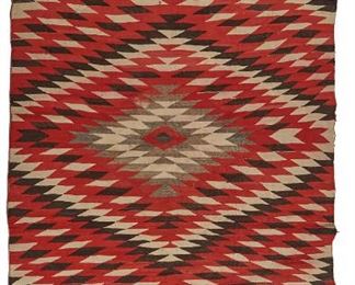 105
A Navajo Regional Rug
First-quarter 20th Century
Woven in red, cream, grey, and dark brown with central radiating serrated diamond, eye-dazzler motif
85" L x 58" W
Estimate: $500 - $700