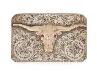 183
A John McCabe Two-Tone Belt Buckle
Sterling silver and 10k yellow gold; Stamped for John McCabe
Centering a gold longhorn steer with simulated ruby eyes over a tooled silver backing
2" H x 3" W
75 grams
Estimate: $1,500 - $2,000
