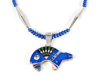 195
A Julian Arviso Double-Sided Inlay Bear Pendant Necklace
20th Century, Dine
Marked to pendant flange: Julian Arviso / Sterling Silver
Multistone mosaic inlay bear with turquoise, spiny oyster, onyx, lapis lazuli, opal, and coral banded in sterling and suspended from a graduated strand of lapis lazuli beads with silver terminals and spacers
22" L 2.75" H 2.90" W
98 grams gross
Estimate: $800 - $1,200