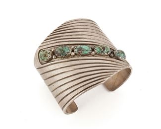 199
A Southwest Turquoise Wide Cuff Bracelet
Mid-20th Century; Appears unsigned
A heavy cuff topped with five turquoise stones diagonally set across the top
7" L x 2.5" W
161 grams
Estimate: $300 - $500