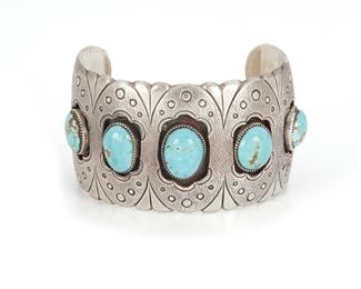 202
A Southwest Silver And Turquoise Cuff Bracelet
Mid-20th Century; Stamped: KS with zigzag below [maker unidentified]
A silver cuff set with five cabochon turquoise stones in a shadowbox mount
6.75" L x 1.5" W
84.5 grams
Estimate: $600 - $800