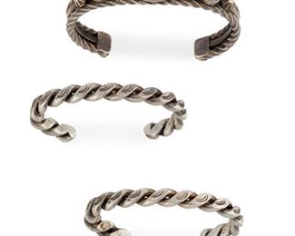 229
Three Navajo Twisted-Wire Bracelets
Second-quarter 20th Century
Comprising a twisted wire cuff centering turquoise cabochons and applied silver cones together with a pair of twisted wire cuffs
Largest: 7.5" C x .5" H, wrist opening: 1.5"
146.5 grams
3 pieces
Estimate: $500 - $700