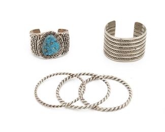 232
Five Southwest Silver Bracelets
Mid-20th Century or later
Comprising a stacked wire cuff, a turquoise-set cuff with a rope wire coil motif, and three twisted silver bangles, 5 pieces
Largest cuff: 5.50" L x 1.60" W
241 grams
Estimate: $400 - $600