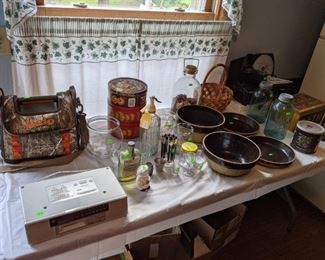 Assorted items in kitchen including stoneware bowls, Ball mason 1/2 gallon jars with lids, meat slicer, and under counter radio.