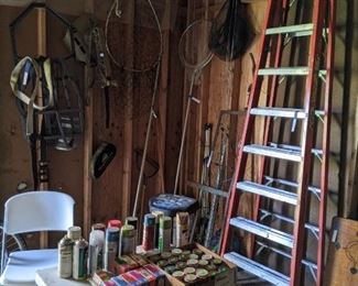 10' A frame ladder, chemicals and hardware, several tools.  Fishing nets, more tree stands, minnow net and trap, and straps.  There is also an extension ladder at the top of the photo.   