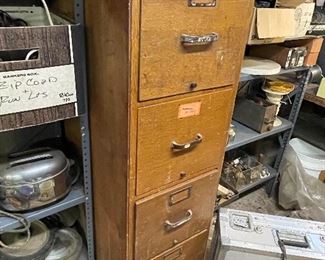 Wooden file cabinet filled with various parts 