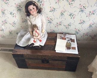 Antique doll on an antique doll trunk